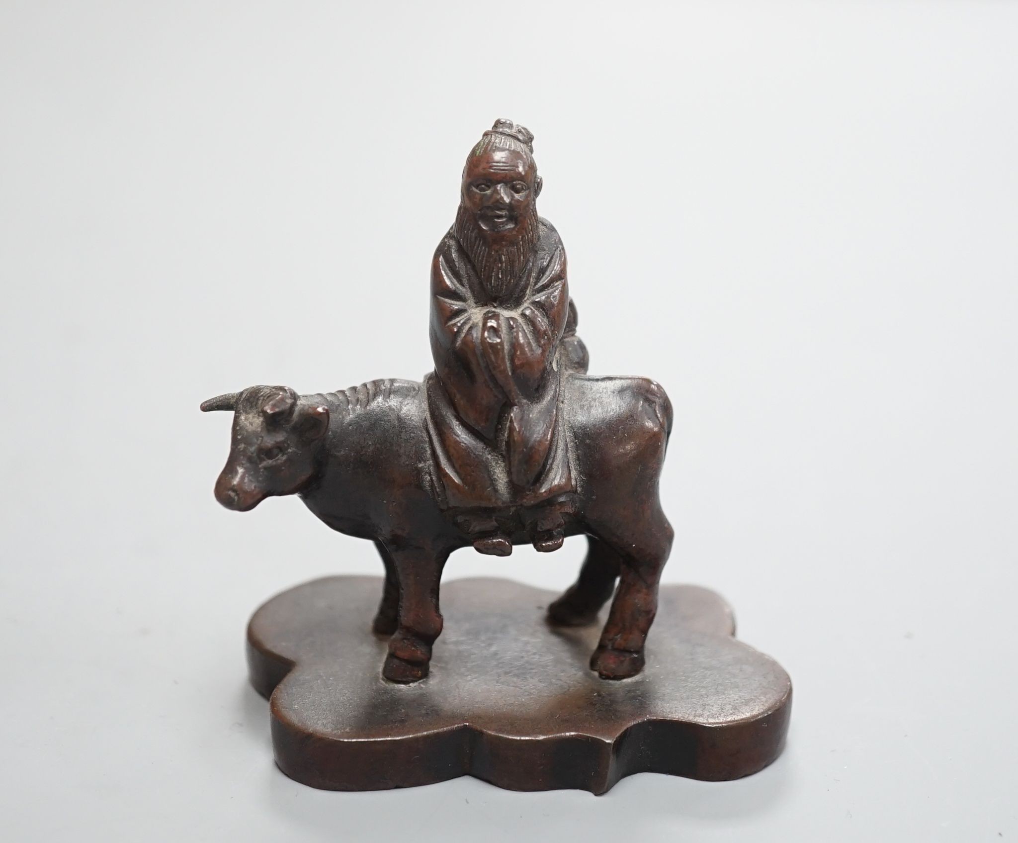 A small Chinese bronze seal of an immortal riding a bull and a Tibetan prayer case 9cm